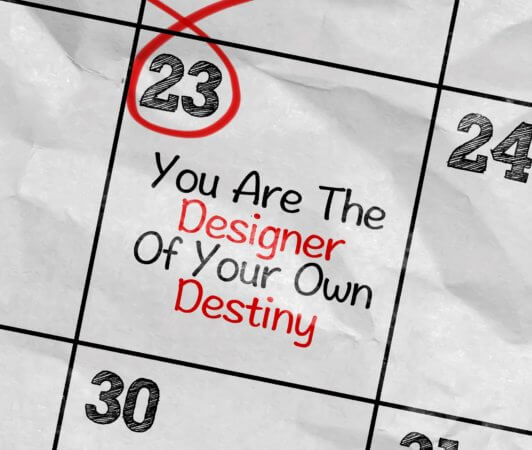 Close up of a calendar with the date "23" circled and the comment "You are the Designer of Your Own Destiny" written on the calendar.